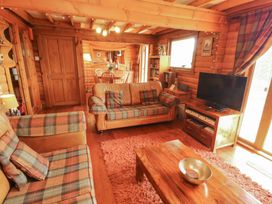 A living room with a sofa and television at Thistle Dubh ('Doo') in Sandyhills
