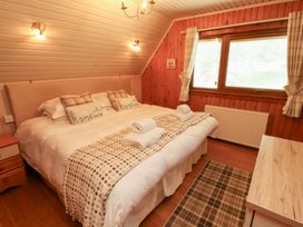 A bedroom with a bed and bedside table at Thistle Dubh ('Doo') in Sandyhills