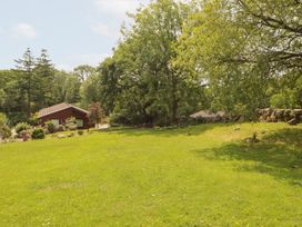A garden with a house and trees at Thistle Dubh (