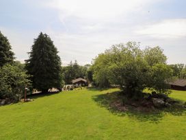 A garden area with trees and a house at Thistle Dubh ('Doo') Sandyhills