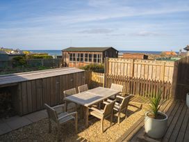 A garden with a table and chairs at Craster Reach in Craster