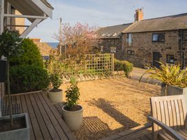 A garden with gravel and planters at Craster Reach in Craster