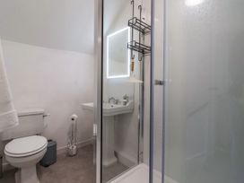 A bathroom with a toilet sink mirror and a shower at 2 Beck Houses in Menethorpe near Malton
