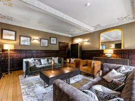 A lounge with sofas armchairs a coffee table and a large mirror at Tudor Grange in Bournemouth