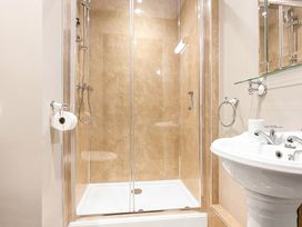 A bathroom with a glass shower enclosure and a pedestal sink at Tudor Grange in Bournemouth