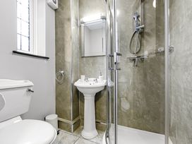 A bathroom with a toilet a pedestal sink a shower enclosure and a window at Tudor Grange in Bournemouth