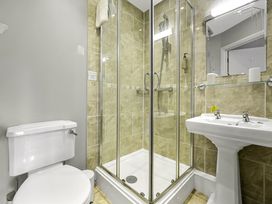 A bathroom with a toilet a glass shower enclosure and a pedestal sink at Tudor Grange in Bournemouth