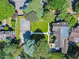 An aerial view of a house with a garden driveway trees and neighboring houses at Tudor Grange in Bournemouth