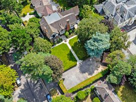 An aerial view of a house with a garden and driveway surrounded by trees at Tudor Grange in Bournemouth