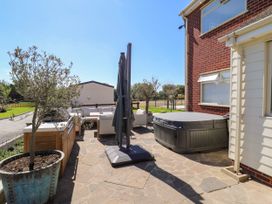 An outdoor space with a hot tub and seating area at The Farmhouse in St. Osyth
