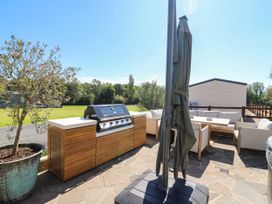 An outdoor area with a grill and seating at The Farmhouse in St. Osyth