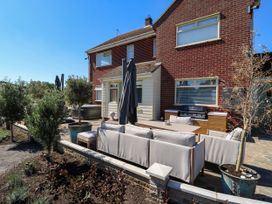 An outdoor patio with seating and grill at The Farmhouse in St. Osyth