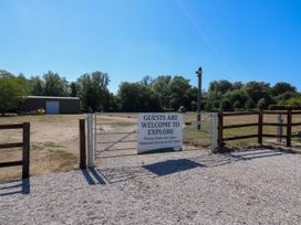 A gate leading to an open space with a sign at The Farmhouse in St. Osyth