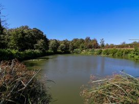 A pond surrounded by trees at The Farmhouse in St. Osyth