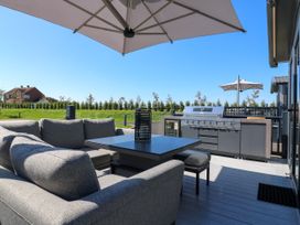 An outdoor seating area with a barbecue grill and umbrella at Lakewood Plot 2 St. Osyth