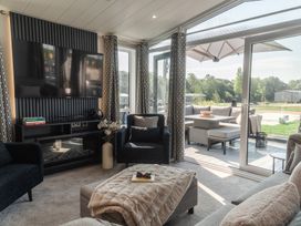 A living room with a television, sofa, and coffee table at Lakewood Plot 2 in St. Osyth