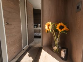 A hallway with sunflowers in a vase and a candle at Lakewood Plot 2, St. Osyth