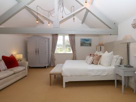 A bedroom with a bed and wardrobe at Apple Mill in Venn Ottery near Sidmouth