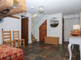 A hallway with chairs and a staircase at Apple Mill Venn Ottery near Sidmouth
