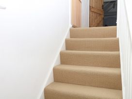 A staircase with carpet and wooden door at Apple Mill in Venn Ottery near Sidmouth