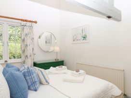 A bedroom with a bed and window at Apple Mill Venn Ottery near Sidmouth