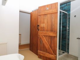A bathroom featuring a wooden door and shower at Apple Mill Venn Ottery near Sidmouth
