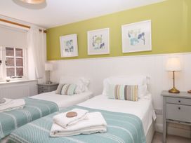A bedroom with two single beds and bedside tables at Apple Mill Venn Ottery near Sidmouth