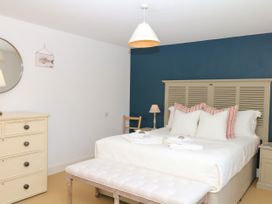 A bedroom with a bed and dresser at Apple Mill in Venn Ottery near Sidmouth
