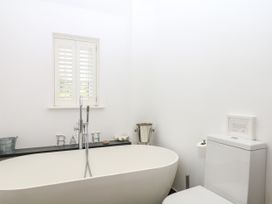 A bathroom with a bathtub and toilet at Apple Mill in Venn Ottery near Sidmouth