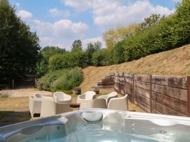 An outdoor area with a hot tub and seating arrangements at Apple Mill in Venn Ottery near Sidmouth