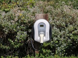 An electric vehicle charger mounted on a wooden post in a garden at Apple Mill Venn Ottery near Sidmouth