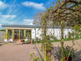 An outdoor area with a house, patio, and planters at Burlodge, Swimbridge near Barnstaple