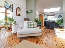 A living room with a sofa and clock at Burlodge in Swimbridge near Barnstaple