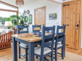 A dining room with a table and chairs at Burlodge Swimbridge near Barnstaple