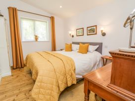 A bedroom with a bed and bedside table at Burlodge Swimbridge near Barnstaple