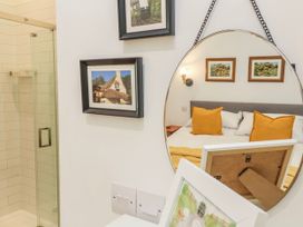 A bedroom with a shower and framed pictures at Burlodge Swimbridge near Barnstaple