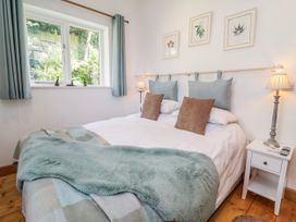A bedroom with a bed and window at Burlodge in Swimbridge near Barnstaple