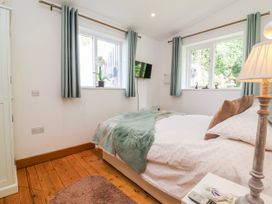 A bedroom with a bed and windows at Burlodge in Swimbridge near Barnstaple