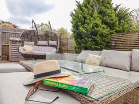 An outdoor seating area with a sofa and hanging chair at Burlodge in Swimbridge near Barnstaple