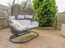 A hanging chair on a patio area at Burlodge Swimbridge near Barnstaple