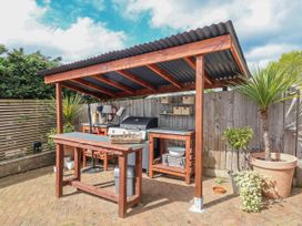 An outdoor kitchen area with barbecue grill and work table at Burlodge Swimbridge near Barnstaple