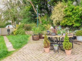 A garden with paved path and flower pots at Burlodge Swimbridge near Barnstaple