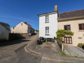 A street with houses and a driveway under a blue sky at The Nook in Brixham