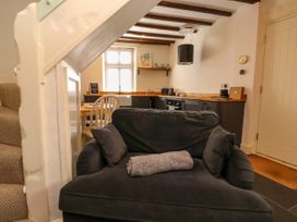 A kitchen and dining area with a dark grey armchair in the foreground at The Nook in Brixham