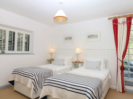 A bedroom with two twin beds and a lamp at Burrows in Venn Ottery near Sidmouth
