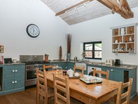 A kitchen with a dining table and stove at Burrows in Venn Ottery near Sidmouth