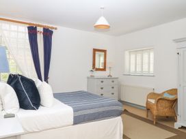 A bedroom with a bed and dresser at Burrows in Venn Ottery near Sidmouth