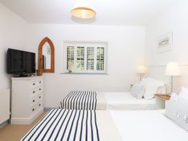 A bedroom with two beds and a television at Burrows in Venn Ottery near Sidmouth
