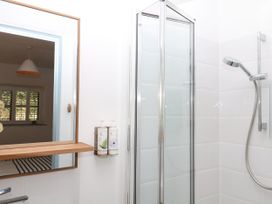 A bathroom with a shower and mirror at Burrows in Venn Ottery near Sidmouth