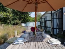 An outdoor dining area with a table and umbrella at Burrows Venn Ottery near Sidmouth